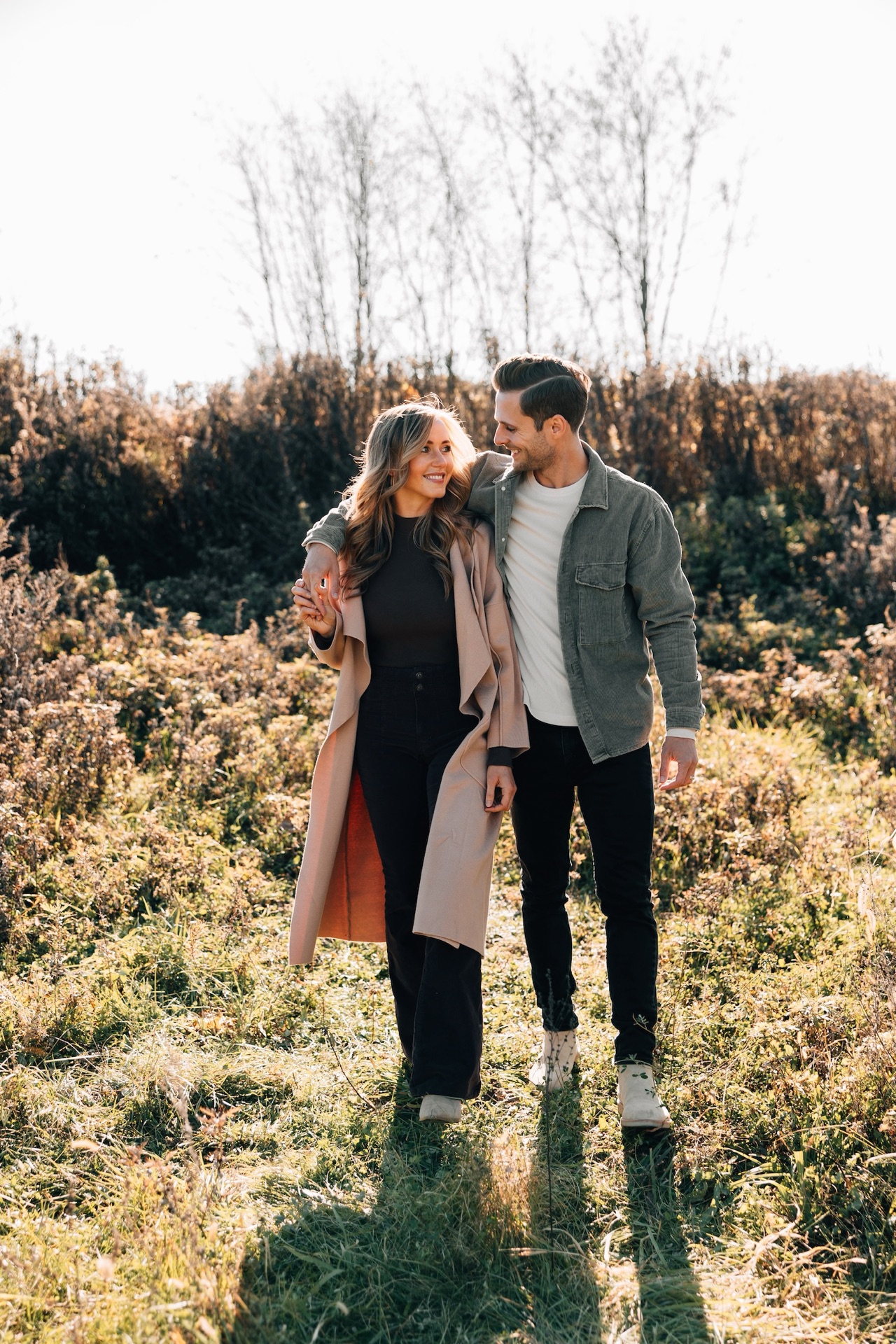 Drew and Bethany Kramer walking through a sunlit field